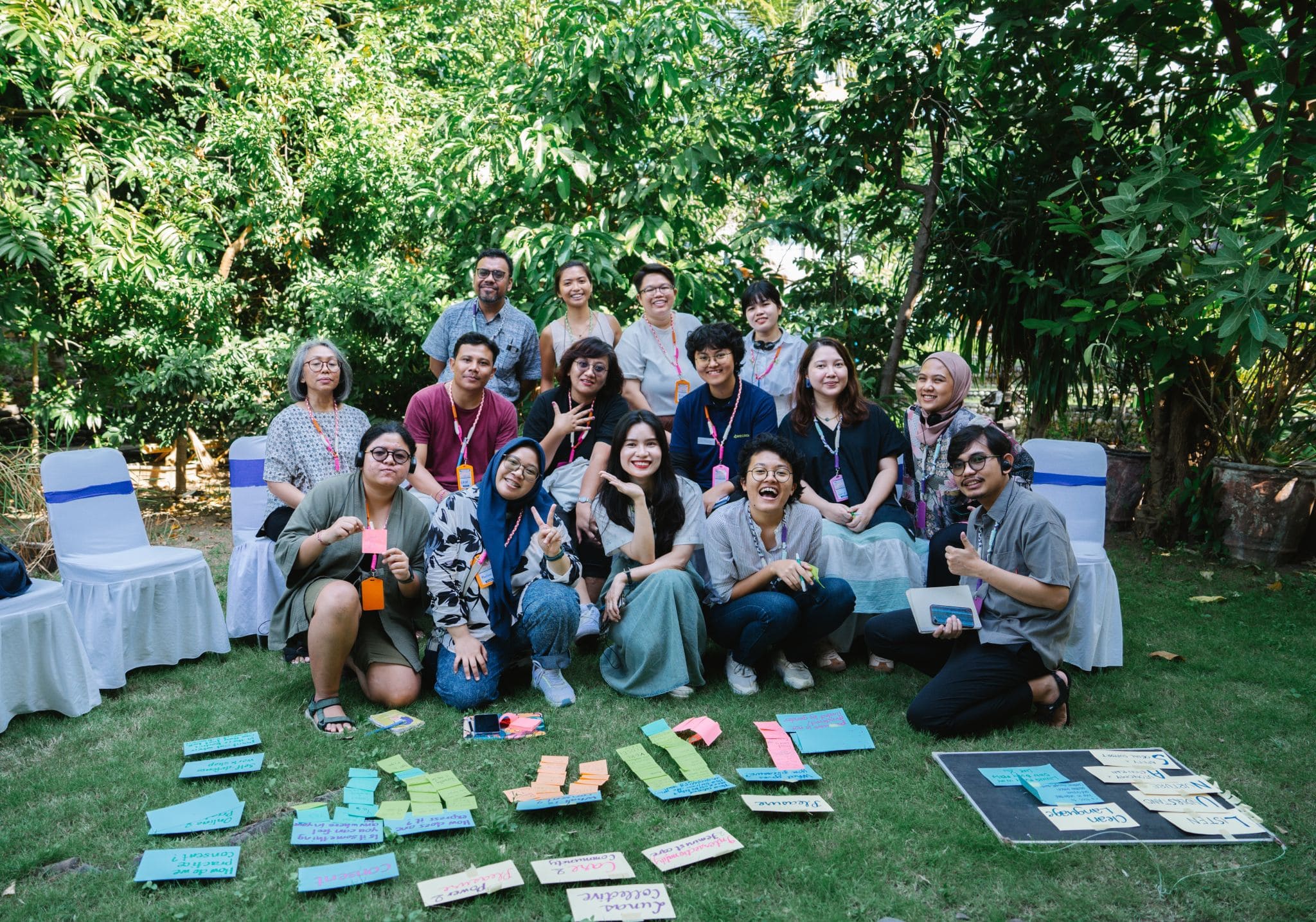 A group of people outside with flashcards and post it notes